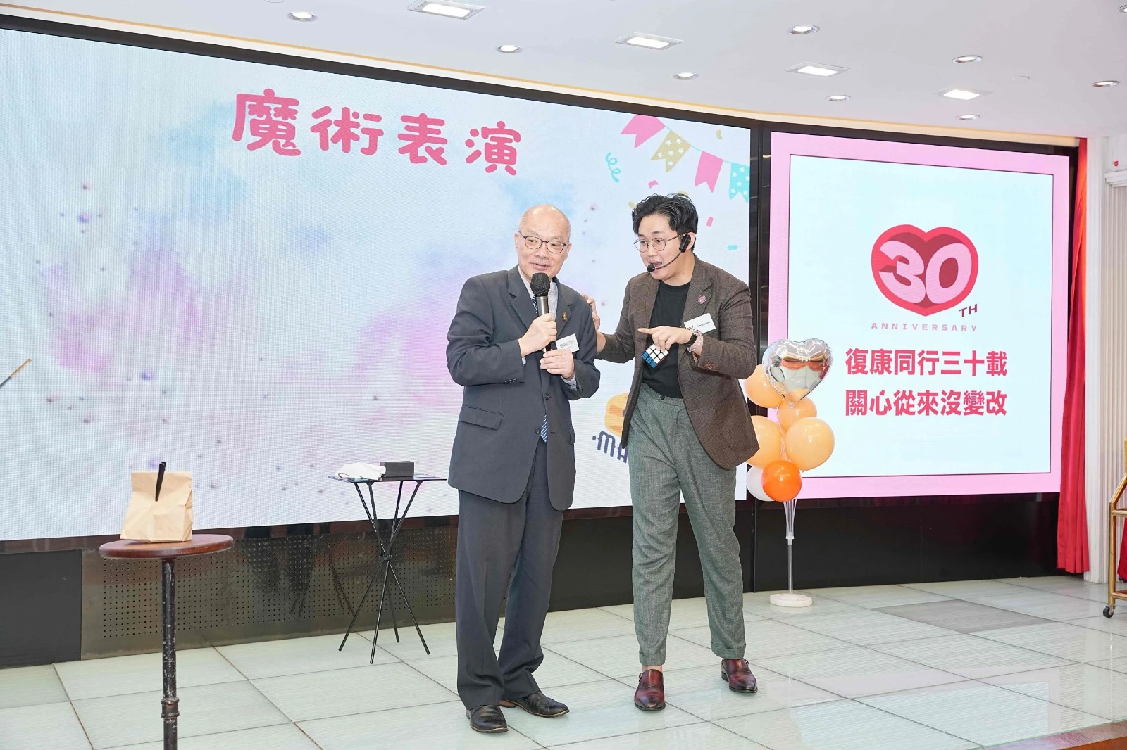 Professional magician performing on a large corporate stage